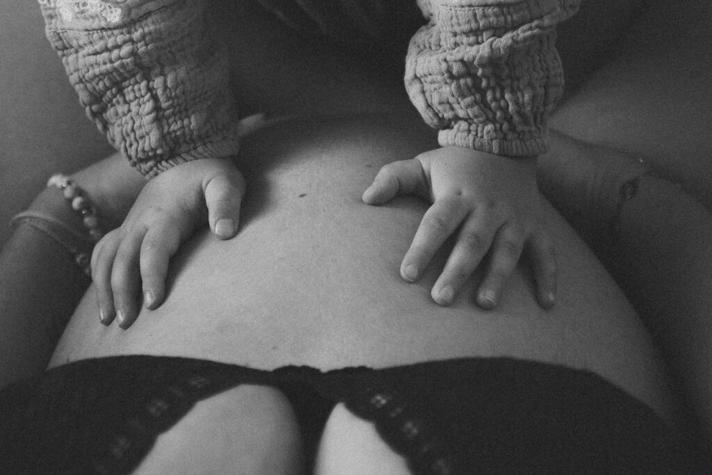deux mains d'enfants sur le ventre rond d'une future maman