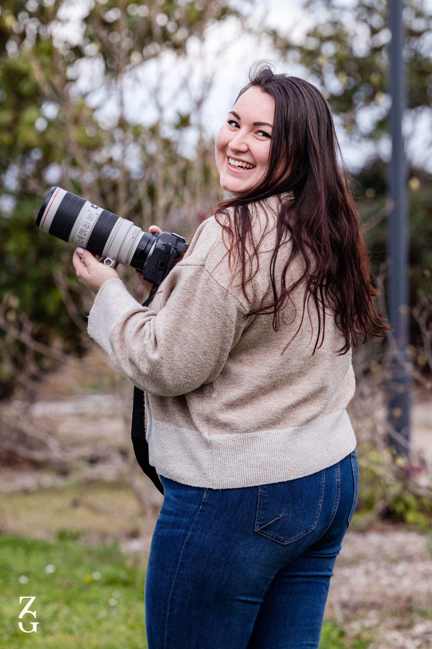 léa brigli, photographe avec son appareil photo qui sourit à la caméra